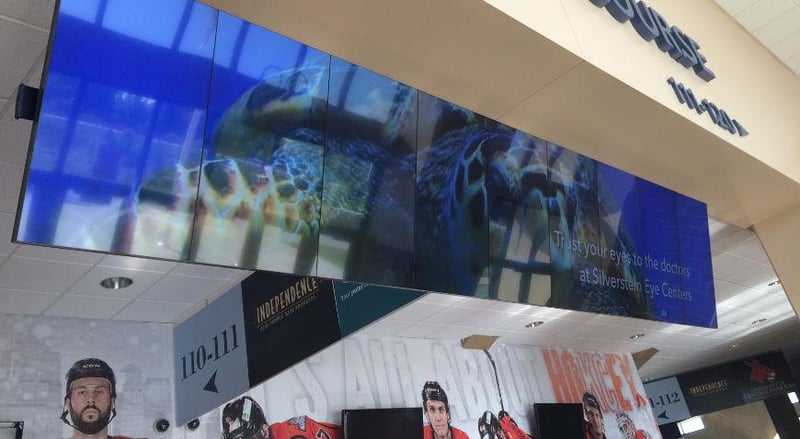 Hängende Videowand in einer NHL-Arena, die eine Werbung für Silverstein Eye Centers zeigt