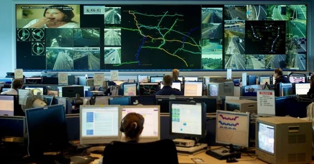 Notfalleinsatzzentrale mit Videowänden, auf denen Live-Verkehrskameras und -Routen angezeigt werden, und Mitarbeitern, die an Arbeitsplätzen arbeiten