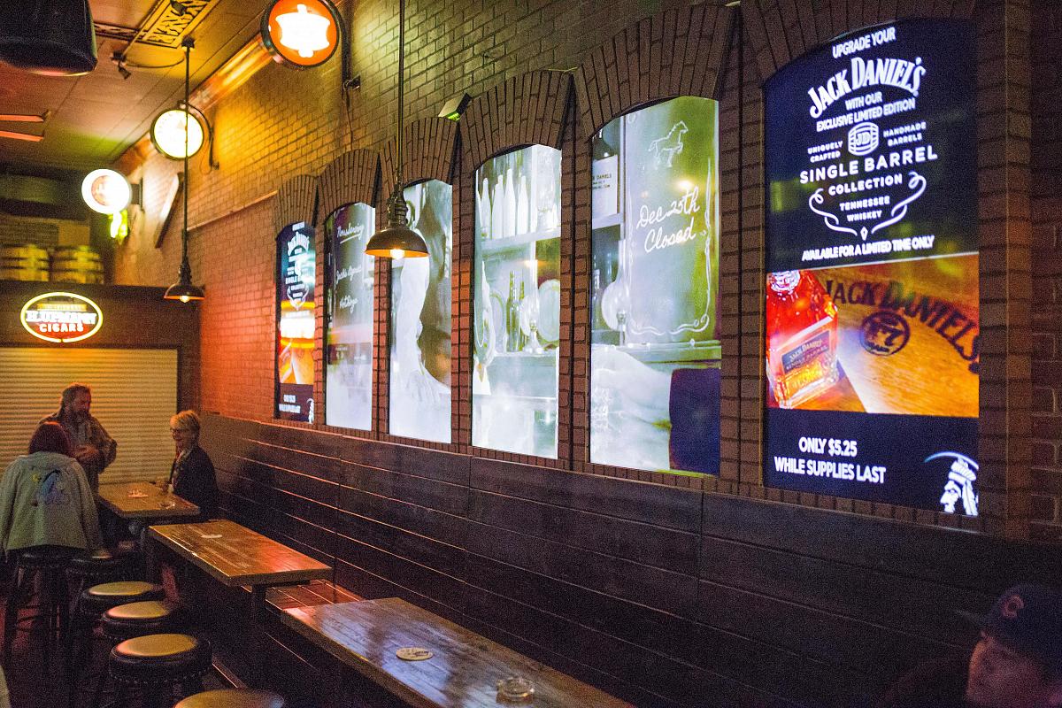 Videowände im Fensterstil in Smokin' Joe's Pub, die Werbung und visuelle Kunst zeigen