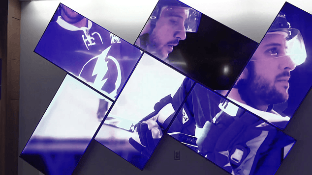 Videowand in der Amalie Arena mit schrägen Bildschirmen, die einen Eishockeyspieler zeigen.