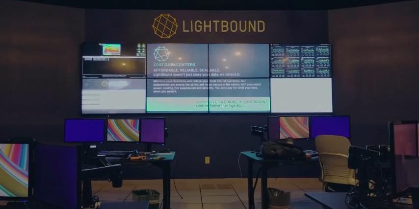 Leerer Lightbound-Kontrollraum mit 2 Arbeitsplätzen und Videowand zur Anzeige von Websites, Daten und Werbung
