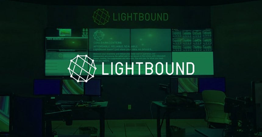 Leerer Lightbound-Kontrollraum mit 2 Arbeitsplätzen und Videowand zur Anzeige von Websites, Daten und Werbung mit grünem Overlay und Logo